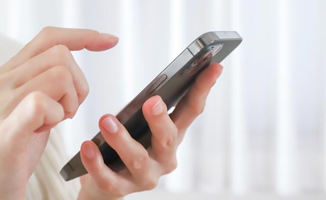 家族葬の葛飾区葬儀社に電話でお問合せしようとしている人の手元。